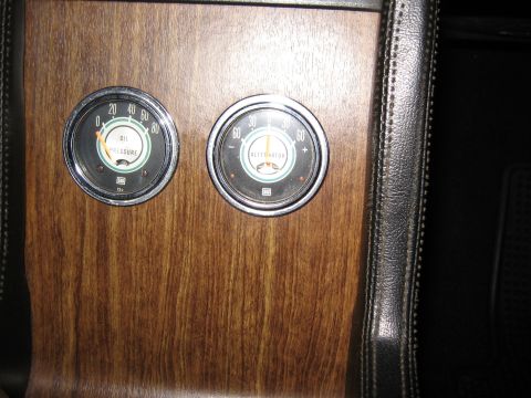 1968 Shelby GT500 - Close-up of two gauges on a wood-grain dashboard, showing oil pressure and alternator readings.