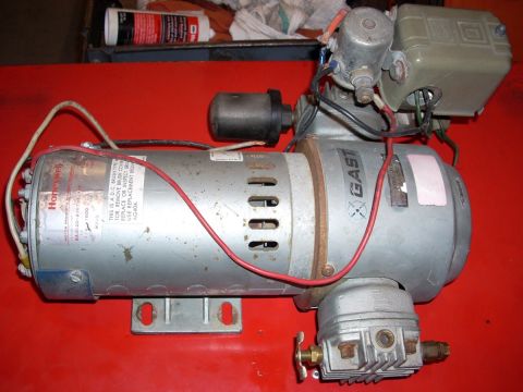 1992 Ford Bronco - A Gast air compressor motor with a Honeywell label is shown on a red surface.