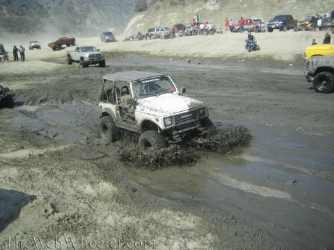 1987 Suzuki Samurai - Off-roading event with multiple vehicles navigating a muddy terrain.