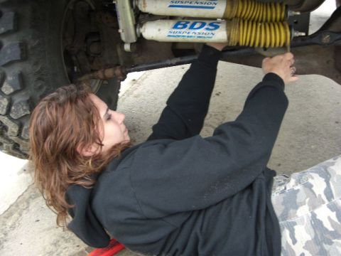 1995 Ford Bronco - A woman performs maintenance on the suspension system of a vehicle, with BDS shocks visible.