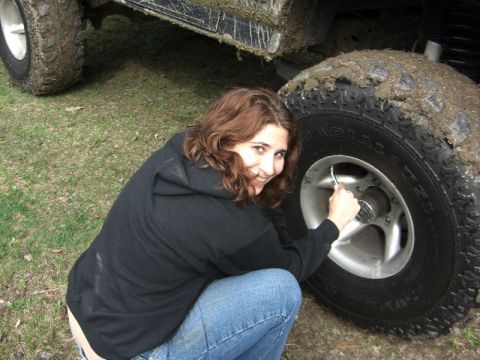 1995 Ford Bronco - Woman airing up a muddy tire on an off-road vehicle.