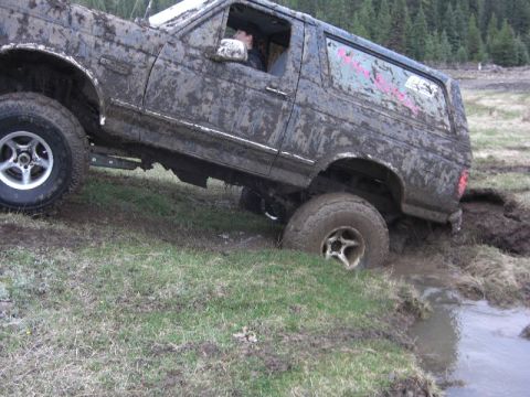 1995 Ford Bronco - This 1995 Ford Bronco is deep in the mud, showing its off-road capabilities.