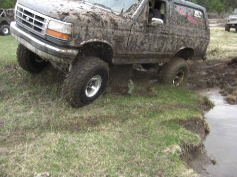 1995 Ford Bronco - This 1995 Ford Bronco is deep in the mud, navigating a challenging off-road course.
