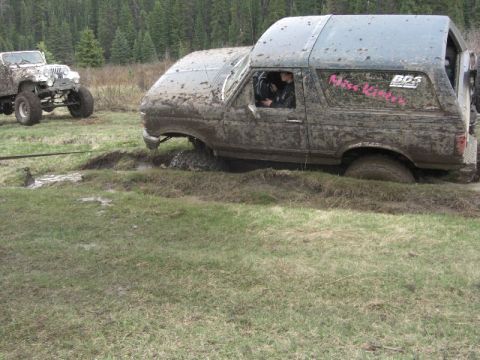 1995 Ford Bronco - Two off-road vehicles are stuck in the mud during an outdoor excursion.