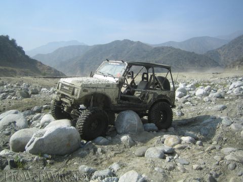 1987 Suzuki Samurai - This Suzuki Samurai, likely from the mid-1980s, is shown traversing a challenging, rocky terrain.