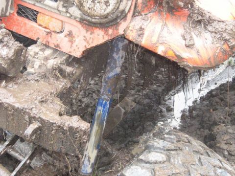1995 Ford Bronco - Mud-covered vehicle chassis and suspension components are visible in this close-up shot.
