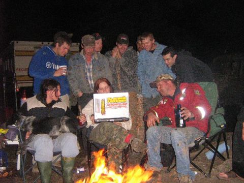 1995 Ford Bronco - People gather around a campfire at night, looking at a box with text and graphics.