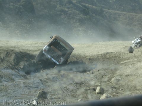 1987 Suzuki Samurai - An off-road vehicle is stuck in a ditch, while another ATV is visible in the background.