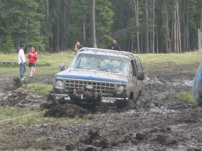 Blue SUV stuck in mud, front view. Appears to be a 1973 Chevrolet K5 Blazer