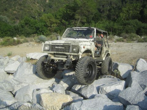 1987 Suzuki Samurai - A driver navigates a , rocky terrain in a lifted Suzuki Samurai.