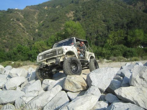 1987 Suzuki Samurai - Suzuki Samurai navigating a rocky terrain during an off-road excursion.