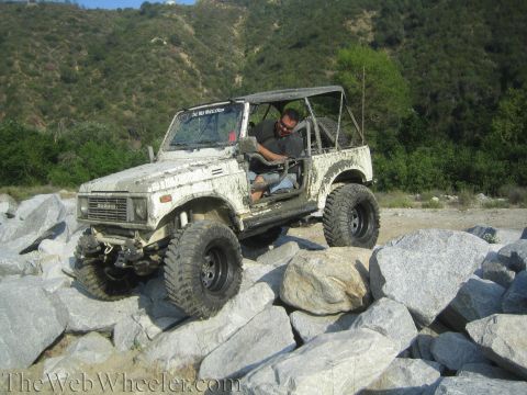 1987 Suzuki Samurai - This Suzuki Samurai is shown off-roading over large rocks, demonstrating its capabilities.