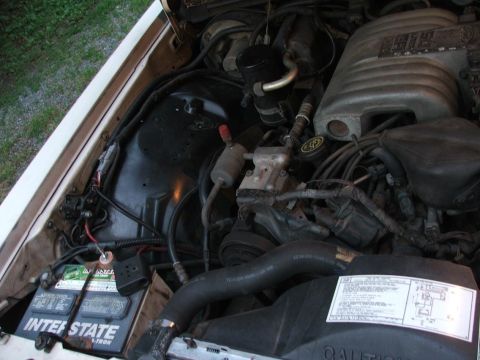 1991 Ford LTD Crown Victoria - Close-up view of the engine compartment, showing the battery and various engine parts.