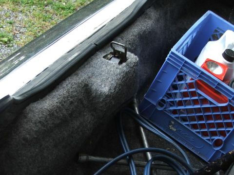 1985 Ford Crown Victoria LTD - The interior of a car's trunk is shown, a blue crate with various items inside, including fluids and a flashlight.