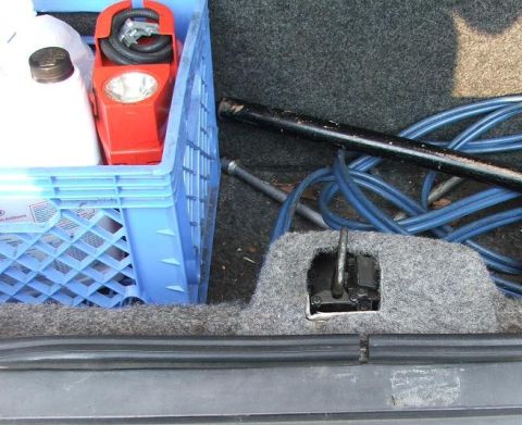 1985 Ford Crown Victoria LTD - Contents of a car trunk, including a crate of supplies and car maintenance tools.
