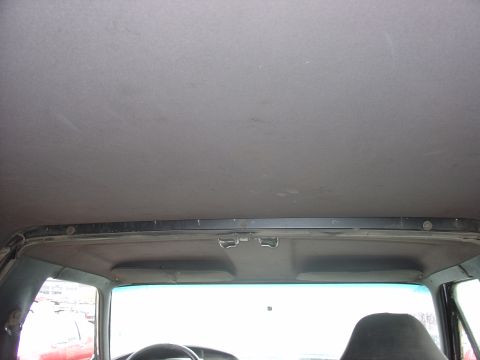 1988 Ford Bronco - Interior view of a car's headliner, showing the upper portion of the windshield and interior trim.