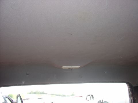 1988 Ford Bronco - The interior headliner of a vehicle, showing the fabric and a central light fixture.