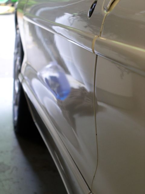 1996 Ford Probe - A close-up view of a car's side panel shows a seam and a reflection.