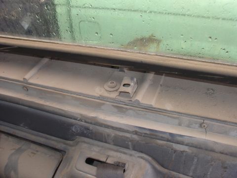 1988 Ford Bronco - This photo shows a close-up of interior trim and a mounting bracket, likely from a vehicle's headliner area.