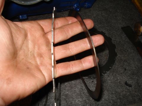 1984 Ford Bronco - Comparison of transmission clutch plates, showing a segmented set versus a solid ring, likely for a rebuild.