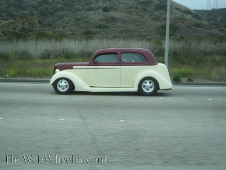 Cream and maroon 1930s coupe street rod on a freeway