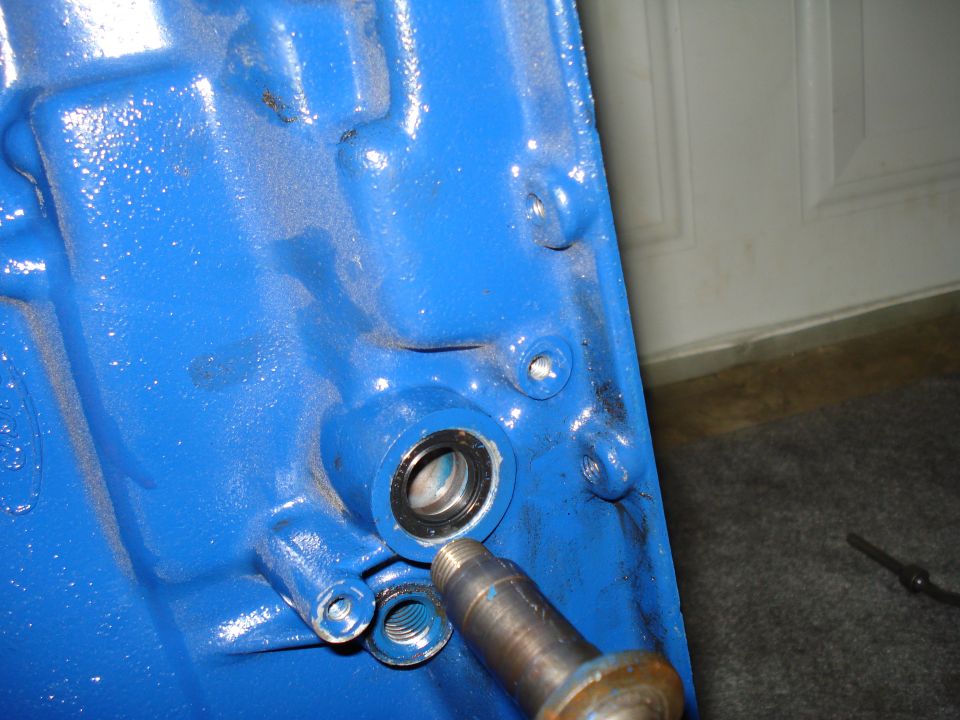Blue engine block part with a bearing and a metal shaft inserted