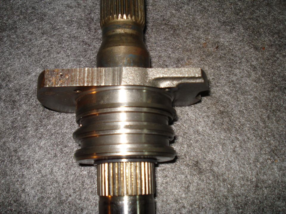 Close-up of a splined shaft with a flange and bearing assembly