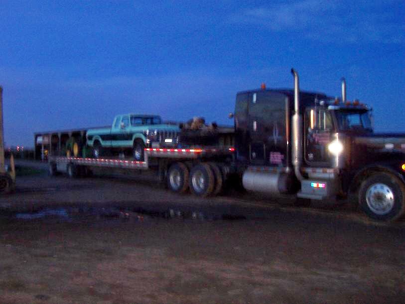 Light blue Ford F-Series pickup truck on a flatbed trailer
