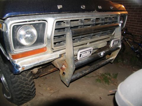 1978 Ford Bronco - Front view of a Ford truck's grille and bumper, Hella auxiliary lights and a custom skid plate.