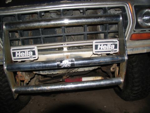 1978 Ford Bronco - Close-up of a truck's front grille and bumper assembly, auxiliary lighting and a skull decal.
