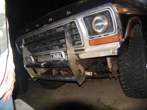 1978 Ford Bronco - The front end of a 1978 Ford Bronco shows its grille, headlights, and a custom brush guard with Hella auxiliary lights.