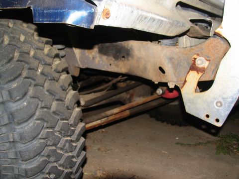 1978 Ford Bronco - Detail shot of a heavily treaded tire and heavily rusted frame components, suggesting off-road use.