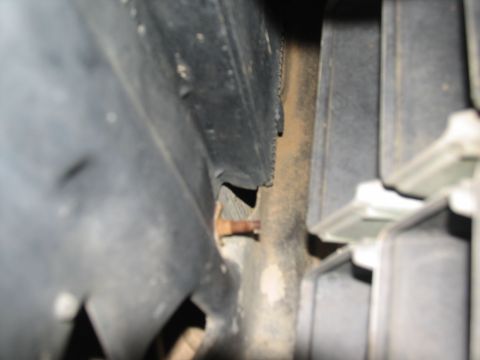 1978 Ford Bronco - A close-up view shows a rusty bolt adjacent to black plastic trim, with no clear vehicle identification visible.