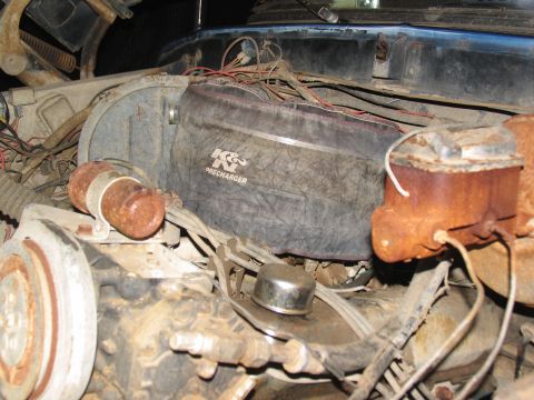 1978 Ford Bronco - Close-up view of a vehicle's engine bay, a K&N Precharger air filter and a heavily rusted brake fluid reservoir.