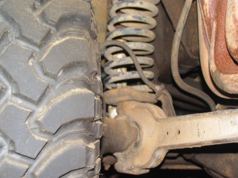 1978 Ford Bronco - This image shows a close-up view of a vehicle's suspension system and a large tire.