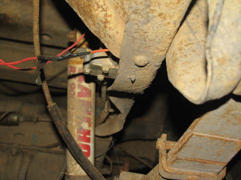 1978 Ford Bronco - Close-up of rusty suspension components and a Rancho shock absorber with visible red wiring.