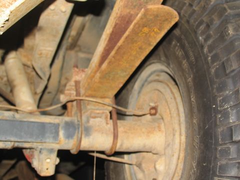 1978 Ford Bronco - Close-up view of the rear leaf spring suspension and tire of a 1978 Ford Bronco, showing some yellow markings on the spring.