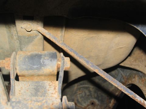 1978 Ford Bronco - Underside view of a vehicle's rusty rear suspension system and fuel tank.