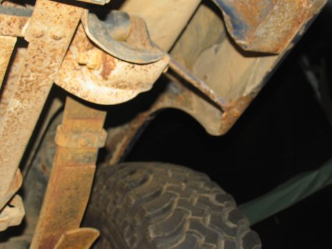 1978 Ford Bronco - Underside view of a vehicle's suspension components and tire, showing significant rust.
