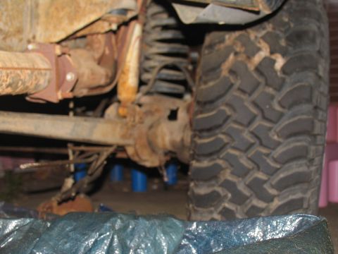 1978 Ford Bronco - Close-up view of a vehicle's heavily rusted rear axle and suspension components.