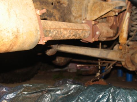 1978 Ford Bronco - Close-up view of the undercarriage, showing rusty exhaust and suspension components, suggesting a vehicle in need of restoration.