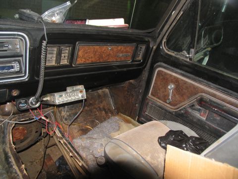 1978 Ford Bronco - The interior of a 1978 Ford Bronco shows its wood-grain trim and a mounted CB radio, indicative of its era.