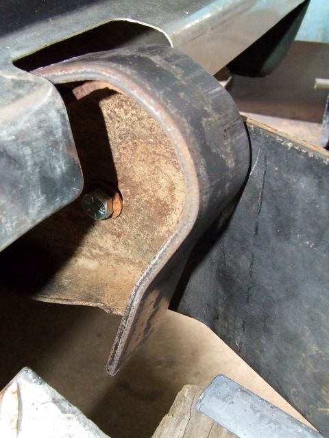 1979 Ford Bronco - This photo shows a close-up view of a rusty metal bracket attached to a vehicle's frame, likely part of a bumper assembly.