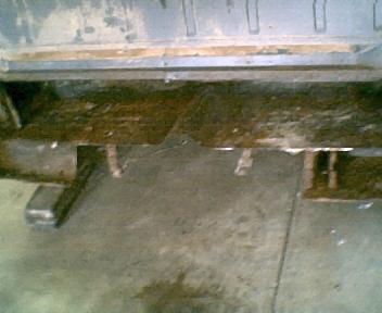 1966 Ford Ranchero - Close-up view of a heavily rusted vehicle rear bumper and frame, showing significant wear and tear.