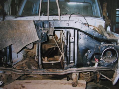 1975 Ford F-100 - The front end of a Ford truck is disassembled, revealing the engine bay and chassis components.
