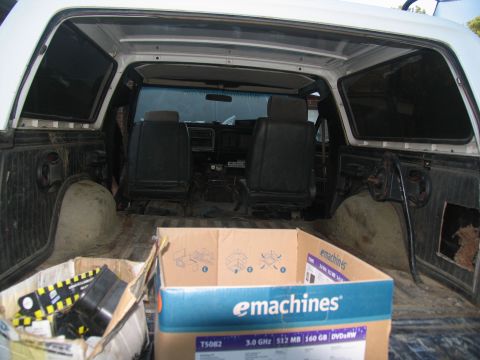 1978 Ford Bronco - The interior of a white SUV is visible, showing black seats and a cardboard box in the cargo area.
