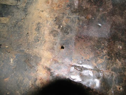 1978 Ford Bronco - Close-up of a corroded metal surface, likely a vehicle's floor pan, showing signs of wear and damage.