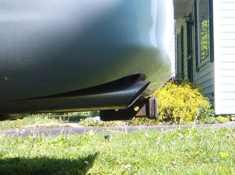 2003 Ford Crown Victoria - Vehicle exhaust pipe and trailer hitch visible from a low angle, with grass and a house in the background.