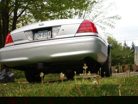 2003 Ford Crown Victoria - The rear of a silver sedan is shown, with a license plate reading EGN-8584.