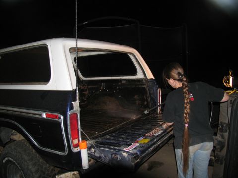 1978 Ford Bronco - A person pressure washes the bed of a 1978 Ford Bronco, which is dark blue with a white camper shell.